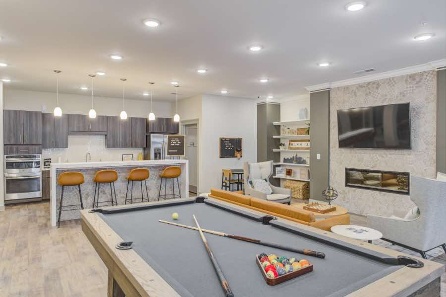 When trying to get approved for an apartment with an upscale clubhouse like this one at Penrose on Mass, make sure you fill out the application completely and have your security deposit ready. Apartment clubhouse with pool table, breakfast bar, and seating area with TV.